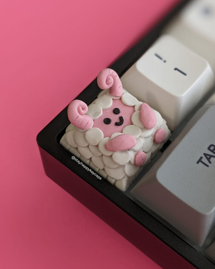 Pink sheep demon artisan keycap on a mechanical keyboard.