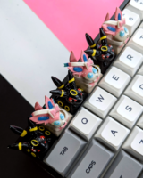 Pokemon Umbreon and Sylveon keycaps on the top row of a mechanical keyboard in a pattern.